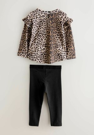 Langärmliges Oberteil im Leopardenmuster mit Rüschensäumen, kombiniert mit schwarzen Leggings. Das Oberteil hat einen runden Halsausschnitt und einen Druckknopfverschluss hinten.