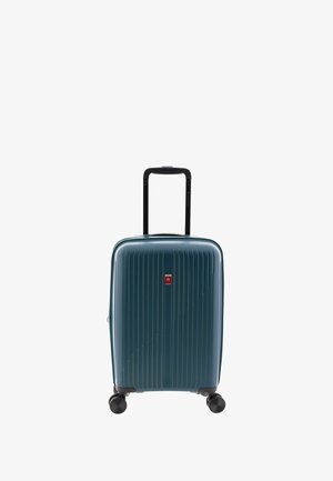 Maleta de ruedas en material de policarbonato color teal, con textura acanalada vertical, esquinas protectoras y un mango retráctil negro.