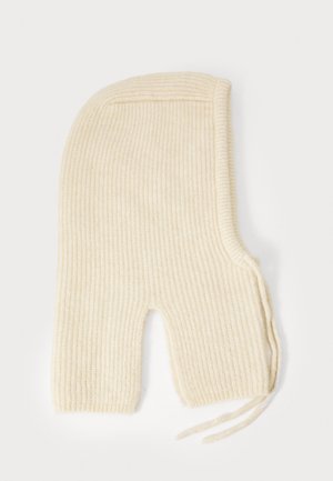 Balaclava tricotée côtelée de couleur crème avec des ouvertures pour les yeux et la bouche. Présente des liens sur un côté pour un ajustement sécurisé. Texture douce tout au long.