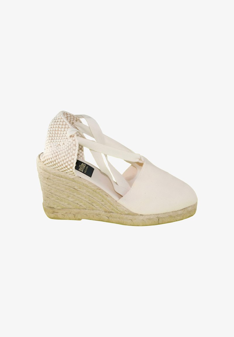 Alpargata cuña de lona blanca con tacón tejido, correas para el tobillo y suela envuelta en yute, mostrada de perfil sobre un fondo blanco.
