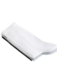 Tri páry zložených podkolienok na sebe, farby biela, sivá a čierna, na bielom pozadí.