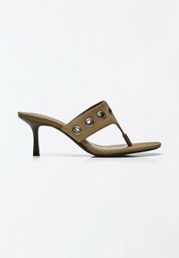 Sandale mule femme en daim marron avec un petit talon et des œillets métalliques ronds sur la bride supérieure.