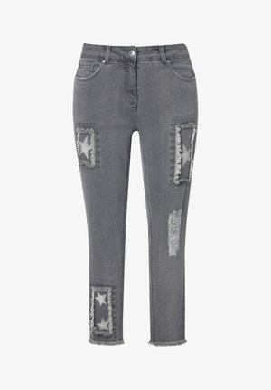 Jeans de mezclilla gris con parches desgastados. Presenta patrones de estrellas, bordes deshilachados y un diseño de corte ajustado. Estilo de cinco bolsillos con cierre de botón.