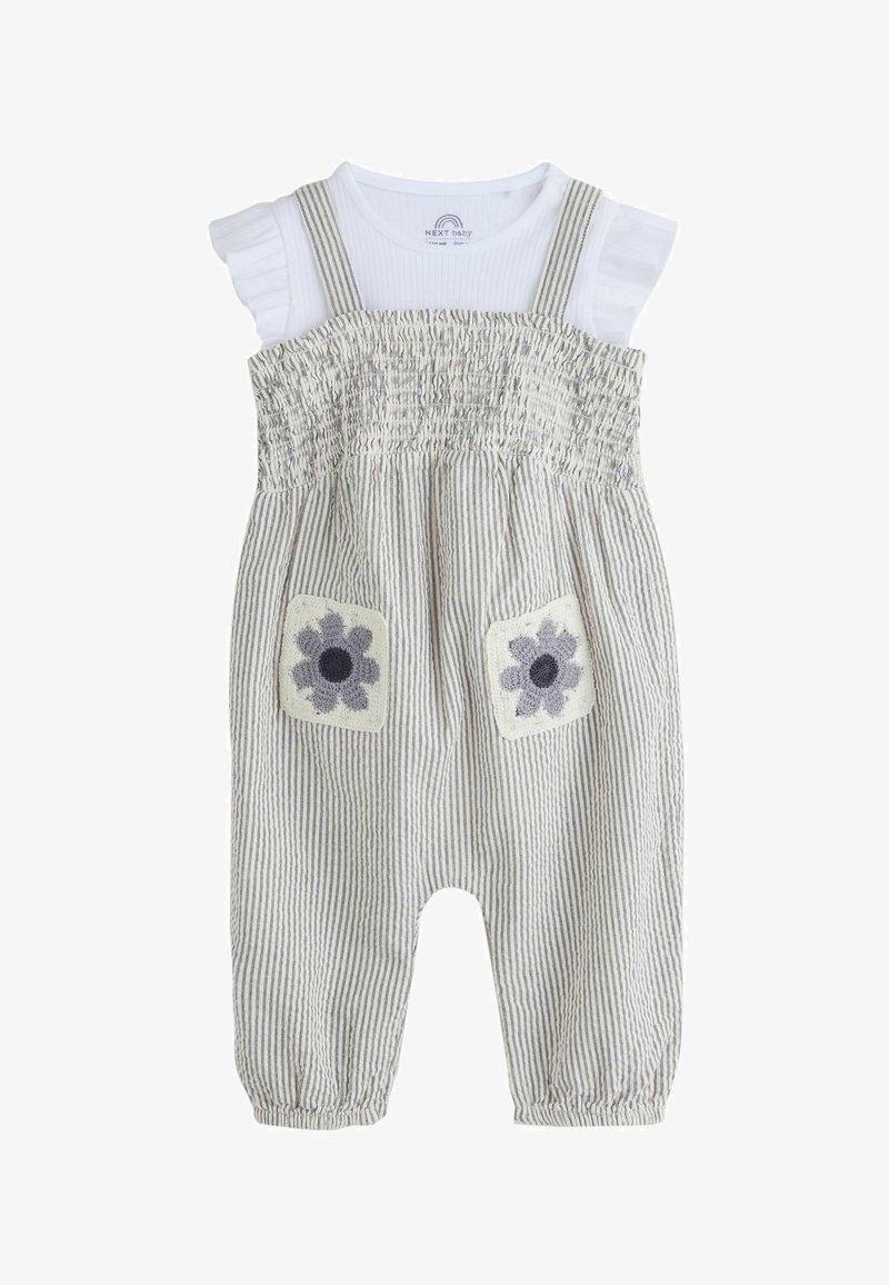 Biały, krótkorękawowy kombinezon niemowlęcy w szare pionowe paski, z marszczonym przodem, ramiączkami na ramionach oraz dwoma kwadratowymi kieszeniami z kwiatowym wzorem na nogawkach.