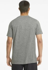 Grå t-shirt med kort ärm och rund halsringning, tillverkad av ett slätt, lätt material, med en enkel design utan mönster eller detaljer.