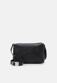 Borsa a tracolla nera in pelle con logo "CK" in rilievo, texture liscia, hardware in argento, tracolla regolabile, forma rettangolare.