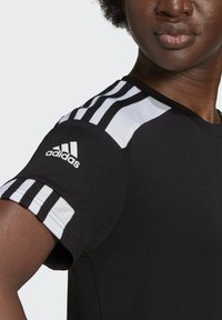 Schwarzes Sportshirt mit weißem Drei-Streifen-Design auf der Schulter, Adidas-Logo auf dem Ärmel, aus glattem Stoff mit einer taillierten Passform.