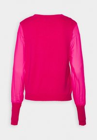 Haut à manches longues rose vif avec dos uni et manches transparentes translucides, vu de dos.