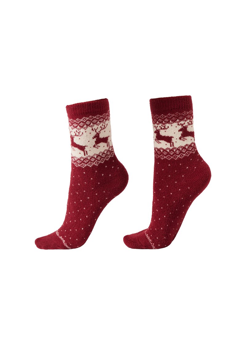 Red knit socks with a white reindeer pattern on a decorated band at the top, textured body, and scattered white dots. Crew length design.