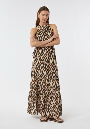 Maxi sukienka w tribalowy wzór w brązowych, beżowych i czarnych kolorach. Posiada halter neck, warstwowy krój oraz podkreśloną talię. Noszona z płaskimi sandałami.