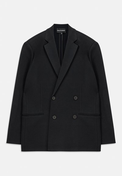 Blazer preto de corte duplo com lapelas de pico, quatro botões e dois bolsos frontais, colocado em plano sobre um fundo branco.