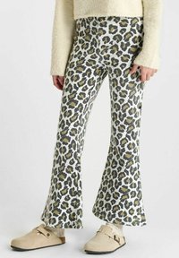 Wijde leopardprint broek in wit, grijs en olijfgroen; zachte stof met een gestructureerde afwerking. Gepaard met beige klompen.