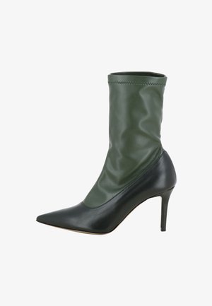 Bottine verte et noire avec un design ajusté et drapé en cuir lisse. Présente une coque pointue et un talon aiguille.