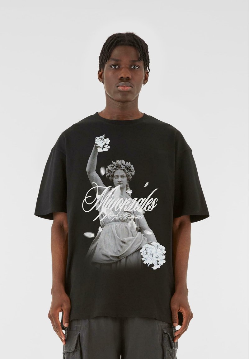 Sort T-shirt med et monokromt grafisk motiv af en klassisk statue, der holder blomster, med hvid tekst ovenpå. Korte ærmer og afslappet pasform.