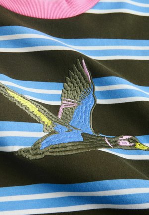 Gestreiftes Stoff-T-Shirt in Braun mit blauen und weißen Streifen. Vorn mit einem gestickten Vogel in Blau, Gelb und Pink verziert.