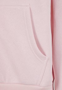 Lyserød sweatshirt med kængurulomme, ribbet kant og glat tekstur, med subtile syningsdetaljer på stoffet.