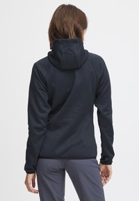 Felpa aderente blu navy con un grande cappuccio, maniche lunghe e cuciture piatte, realizzata in tessuto liscio e elasticizzato per il massimo comfort.