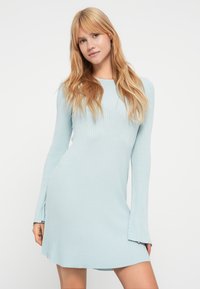 Μακρυμάνικο φόρεμα με ριμπ ύφανση σε ανοιχτό μπλε ύφασμα. Διαθέτει στρογγυλή λαιμόκοψη και εφαρμοστή γραμμή με ελαφριές εξογκώσεις στις μανσέτες.