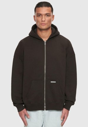 Must värvitud zip-up kapuutsiga dressipluus, mis on valmistatud puuvilla ja sünteetika segust. Dressipluusil on esikott, nööriga kapuuts ja soonikvarrukad. Minimalistlik bränding.