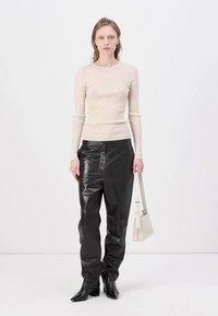 Beige stripete langermet topp, svarte lærbukser, svarte spisse ankelstøvler og en hvit skulderveske. En enkel og moderne look.