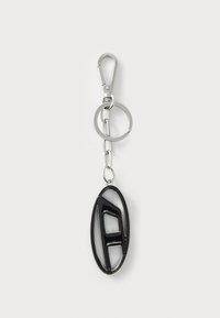 Portachiavi con un pendente ovale nero con un design a "A" ritagliato, attaccato a una clip e anello in metallo argentato. Texture liscia.