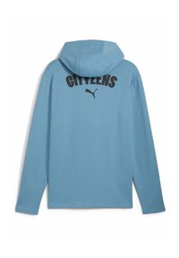 Lys blå hoodie med lange ærmer, der har hætte, sort tekst "CITIZENS" og et Puma-logo på ryggen. Glat tekstur, afslappet design.