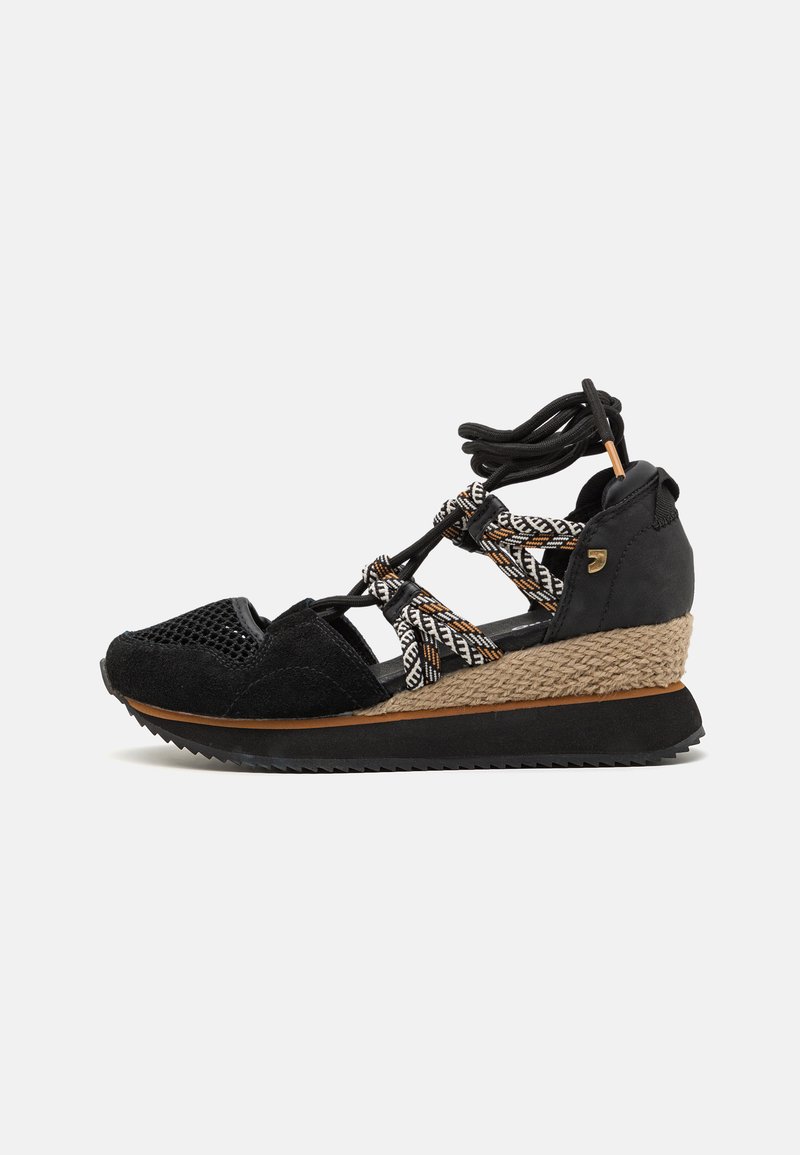 Sandalias de cuña negras con un upper de lona texturizada, detalles trenzados, suela de goma y cordones decorativos para un ajuste seguro.