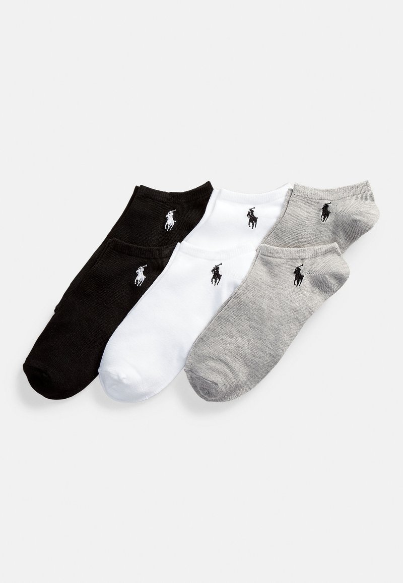 Tre par ankelsockar: svarta, vita och grå. Varje par har en liten broderad logotyp och en jämn stickad struktur.