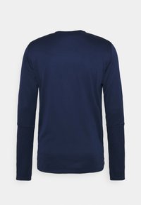 Camisa de manga larga azul marina hecha de un tejido suave, con un escote redondo y mangas ajustadas, con un diseño limpio y minimalist.