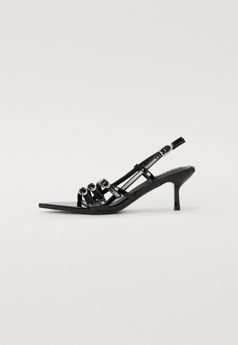 Sandale à talon kitten en cuir verni noir avec trois brides à l'avant, boucles argentées, bout ouvert et bride arrière à la cheville.