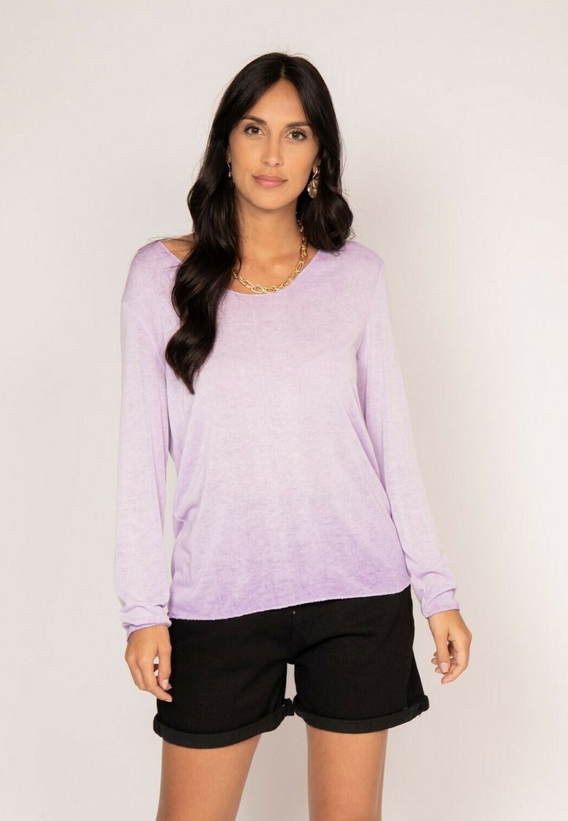 Chemisette longue de couleur violet clair avec une coupe décontractée, décolleté en scoop et texture douce, associée à un short noir à ourlet roulé.
