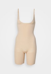 Nude seamless bodysuit with thin adjustable straps, a scoop neck, and mid-thigh length, made from stretchy, smooth fabric.