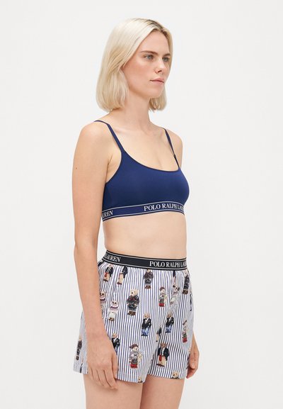 Námornícky bavlnený bralet s nastaviteľnými ramienkami a elastickým pásom; zladené pruhované boxerky s farebnými potlačami bábik. Obe obsahujú detail s logom.