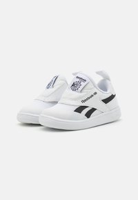 Bijele mrežaste tenisice s crnim detaljima, dizajn na vezivanje, te Reebok brendiranje na lišću. Zaobljeni vrh i teksturirana potplat.