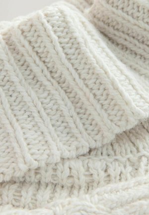 Gruby sweter z dzianiny w kremowym kolorze z prążkowaną fakturą i wypukłymi wzorami, wykonany z miękkiej włóczki, o przytulnym, grubym wyglądzie.