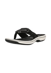 Sandale noire et blanche avec semelle coussinée, bride réglable et semelle intérieure texturée conçue pour le confort et un usage décontracté.