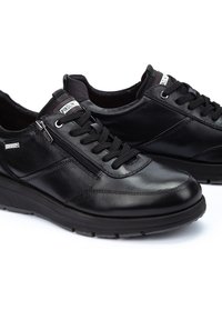 Zapatos de cuero negro con puntera redonda, cierre con cordones y cremallera, acentos texturizados, cuello acolchado y suela de goma.