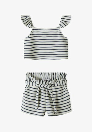 Tenue deux pièces rayée comprenant un haut sans manches avec des bretelles à volants et un short avec une taille élastique et un détail noué. Couleurs : bleu marine et blanc.