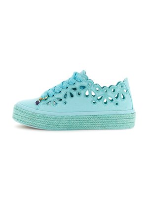 Jasnoniebieski sneaker na płótnie z falistymi brzegami i kwiatowymi wycięciami, grubą teksturowaną podeszwą oraz pasującymi niebieskimi sznurowadłami z małym zawieszką.