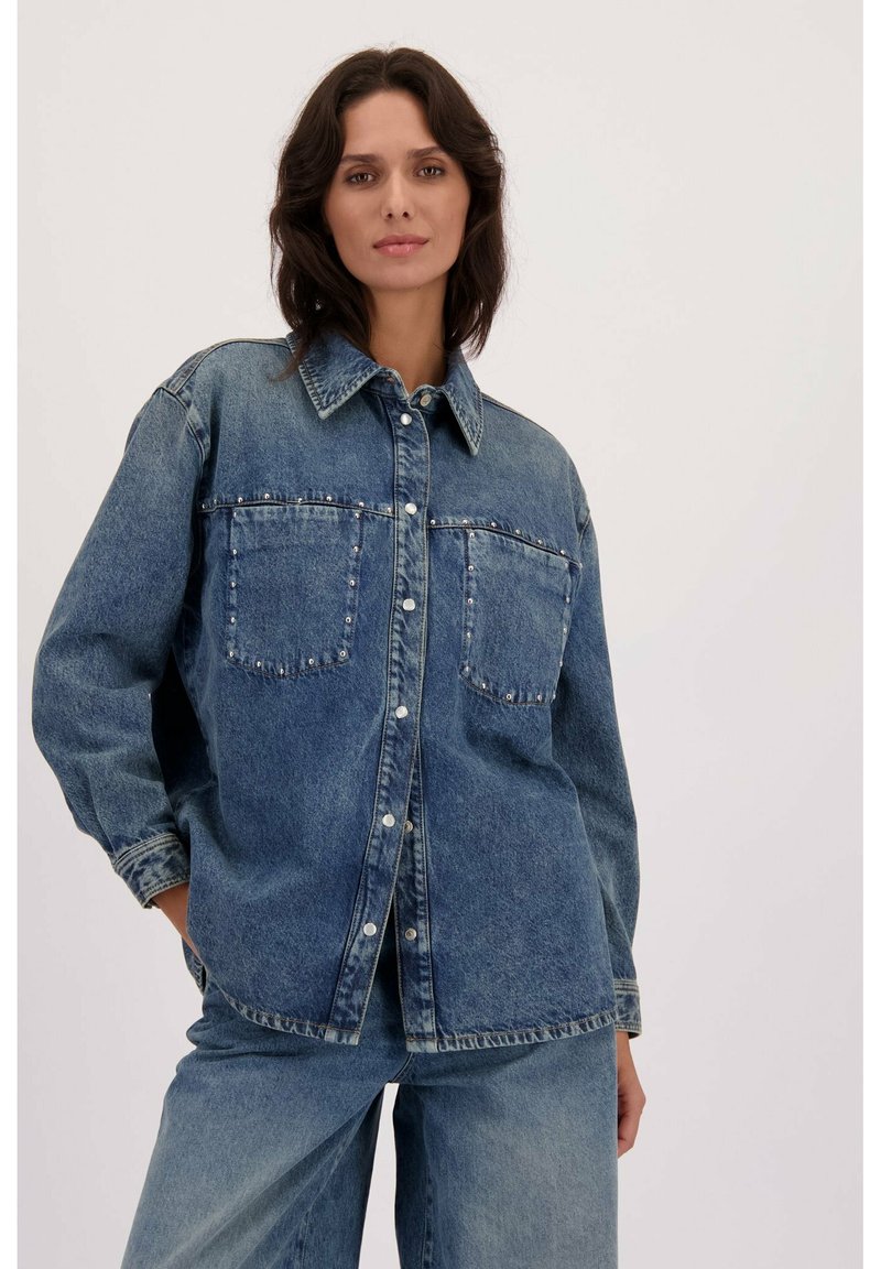 Spijkerblouse in een vervaagde blauwe tint, met knoopsluiting, twee borstzakken met studs, relaxte pasvorm en lange mouwen.