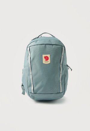 Γαλάζιο σακίδιο με μπροστινή θήκη με φερμουάρ, χειρολαβή στην κορυφή, δύο πλαϊνές θήκες και κόκκινο μοτίβο αλεπούς στο κέντρο της μπροστινής πλάκας.