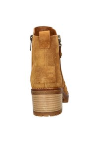 Brown suede ankle boot with a textured heel, zipper detailing, and a pull tab. Features a rounded toe and a sturdy sole.