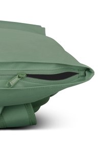 Zöld párna texturált felülettel, melyen cipzár található az egyik szélen. A design téglalap alakú, lekerekített sarkakkal.