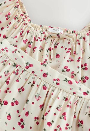 Ziedu kleita no viegla auduma. Krēmkrāsas fons ar maziem sarkaniem zemenēm un zaļām lapām. Raksturīga savāktā izgriezuma un vidukļa detaļa.