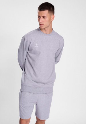 Grijze sweatshirt- en shortset, gemaakt van zachte stof. De top heeft een ronde halslijn en een klein wit logo op de borst. De shorts hebben een elastische taille.