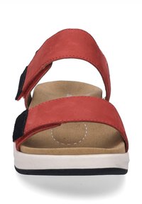 Czerwone zamszowe sandały z dwiema szerokimi regulowanymi paskami, beżową wyściełaną wkładką i białą podeszwą z granatowym akcentem.