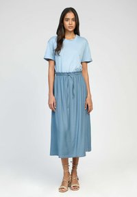 Robe t-shirt bleu clair avec une taille élastique et une jupe fluide. Fabriquée en tissu doux avec des manches courtes, elle présente un design décontracté.