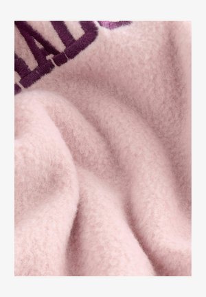 Hellrosa Fleece-Stoff mit einer weichen, flauschigen Textur, der ein gesticktes, dunkelviolettes Design zeigt. Das Material wirkt dick und gemütlich.