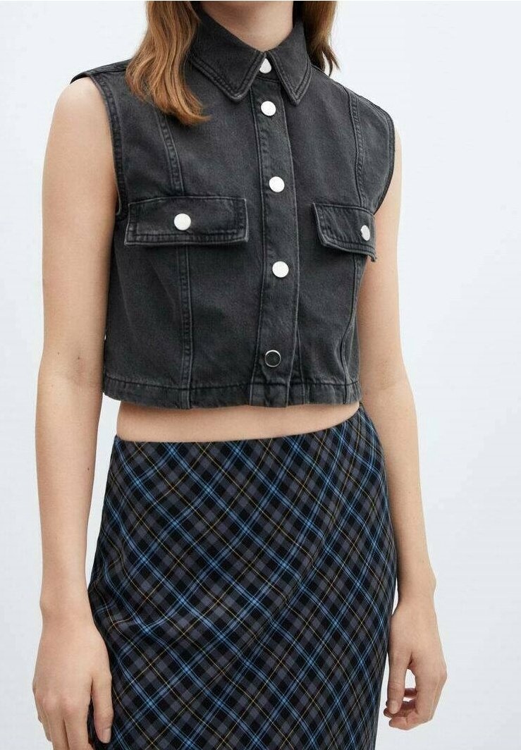 Schwarze, kurz geschnittene Denim-Weste mit Kragen, vorderem Knopfverschluss und zwei Brusttaschen; kombiniert mit einem schwarz-blauen karierten Rock.