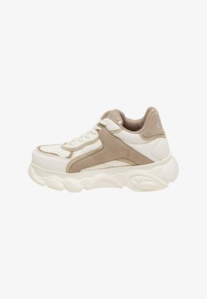 Masywne białe sneakersy z beżowymi akcentami ze zamszu, teksturowanym obszarem sznurowania oraz grubą podeszwą z falistymi wzorami. Okrągły kształt palców z perforacjami.